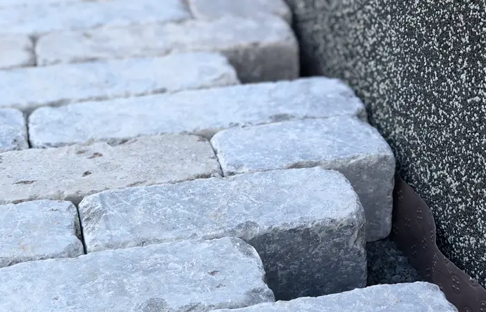 Professionelle Pflasterarbeiten von DMK Bau Reichelsheim - perfekt verlegte Natursteinpflaster für eine Einfahrt und Terrasse.