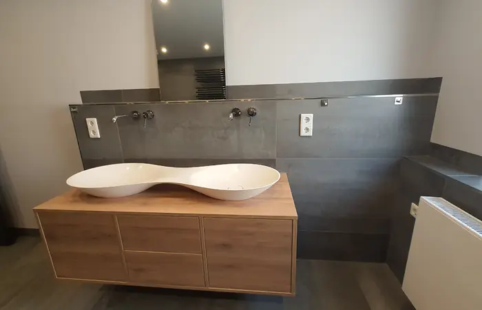 Detailaufnahme einer Badsanierung mit modernen Fliesen, bodengleicher Dusche und hochwertigen Armaturen durch DMK Bau Reichelsheim.