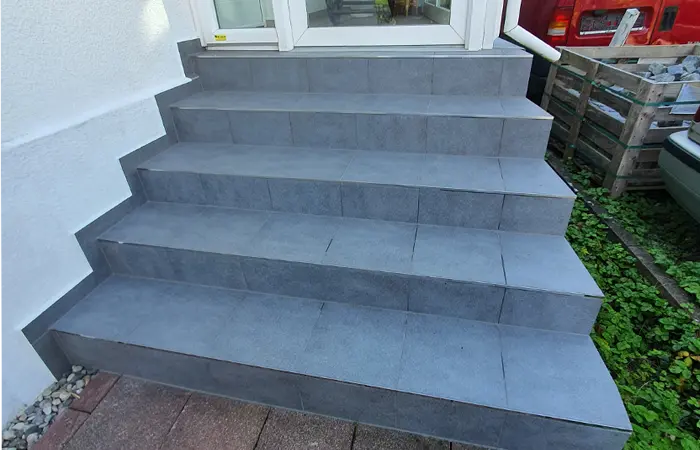 Professionelle Außentreppe von DMK Bau Reichelsheim - elegante Natursteintreppe mit Geländer im Gartenbereich.