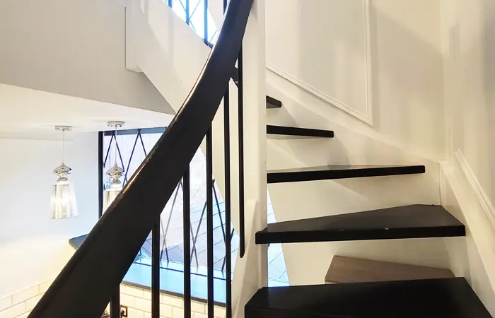 Treppen-Lösung von DMK Bau Reichelsheim - elegante Wendeltreppe mit Glasgeländer für beengte Platzverhältnisse.